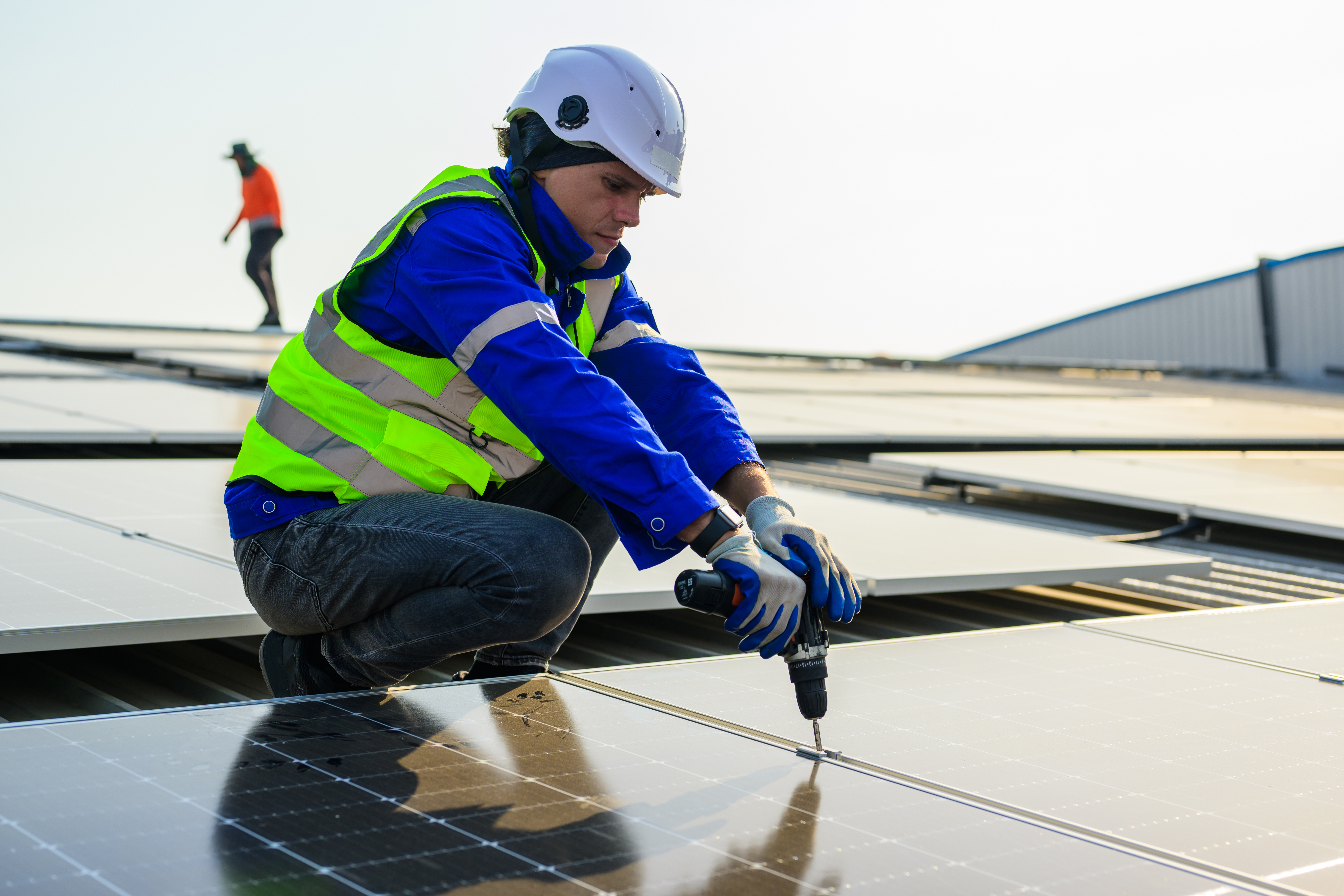 Professional technicians installing solar panels on rooftop